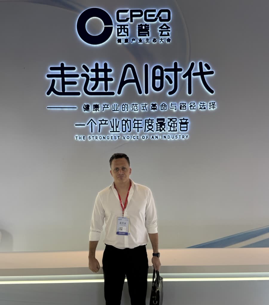 Kevin Maes 站在海南西普会主舞台背景板前。